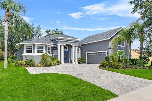 4013 Greystone Dr, Clermont, FL 34711 - ranch-style home with a garage, a front yard, decorative driveway, stucco siding, and a shingled roof