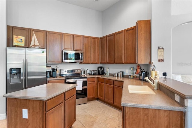 4013 Greystone Dr, Clermont, FL 34711 - kitchen featuring stainless steel appliances, arched walkways, a peninsula, brown cabinets, and light countertops