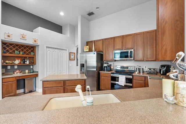 4013 Greystone Dr, Clermont, FL 34711 - kitchen with stainless steel appliances, a high ceiling, brown cabinetry, light countertops, and open shelves