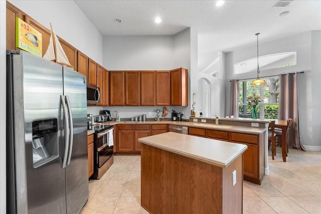 4013 Greystone Dr, Clermont, FL 34711 - kitchen featuring appliances with stainless steel finishes, light tile patterned flooring, light countertops, a center island, and hanging light fixtures