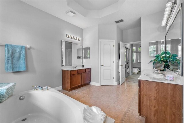 4013 Greystone Dr, Clermont, FL 34711 - bathroom with two vanities, a bath, and tile patterned floors