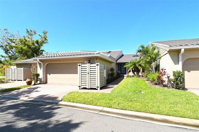 2103 Harbourside Dr Unit 1102, Longboat Key, FL 34228 - view of front facade with an attached garage, stucco siding, driveway, solar panels, and a tiled roof