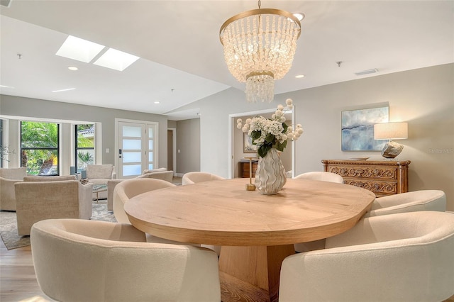 2103 Harbourside Dr Unit 1102, Longboat Key, FL 34228 - dining space featuring a skylight, a chandelier, light wood finished floors, recessed lighting, and vaulted ceiling