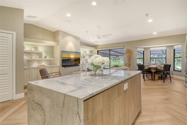 2103 Harbourside Dr Unit 1102, Longboat Key, FL 34228 - kitchen with modern cabinets, lofted ceiling, light stone counters, a spacious island, and recessed lighting
