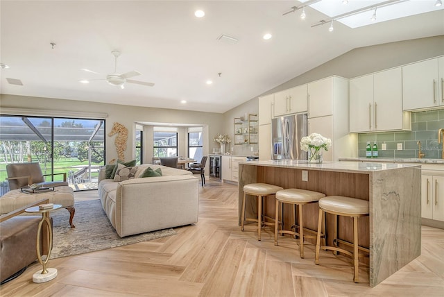 2103 Harbourside Dr Unit 1102, Longboat Key, FL 34228 - kitchen with stainless steel refrigerator with ice dispenser, beverage cooler, a kitchen island, vaulted ceiling, and open floor plan