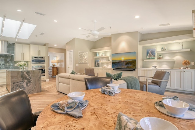 2103 Harbourside Dr Unit 1102, Longboat Key, FL 34228 - dining area featuring a skylight, a ceiling fan, recessed lighting, vaulted ceiling, and built in features