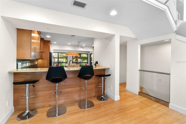 1347 Landings Dr Unit 6, Sarasota, FL 34231 - kitchen with brown cabinets, light wood-style floors, a ceiling fan, a breakfast bar, and recessed lighting