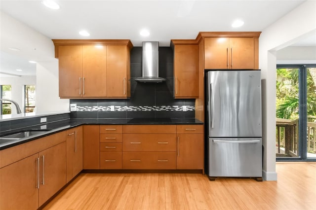 1347 Landings Dr Unit 6, Sarasota, FL 34231 - kitchen featuring freestanding refrigerator, wall chimney range hood, light wood-style flooring, backsplash, and recessed lighting