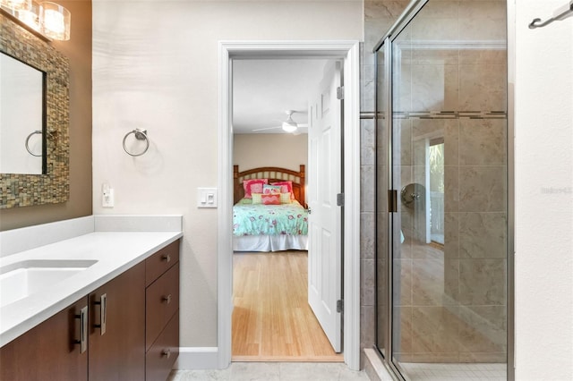 1347 Landings Dr Unit 6, Sarasota, FL 34231 - ensuite bathroom with vanity, a shower stall, ceiling fan, and wood finished floors