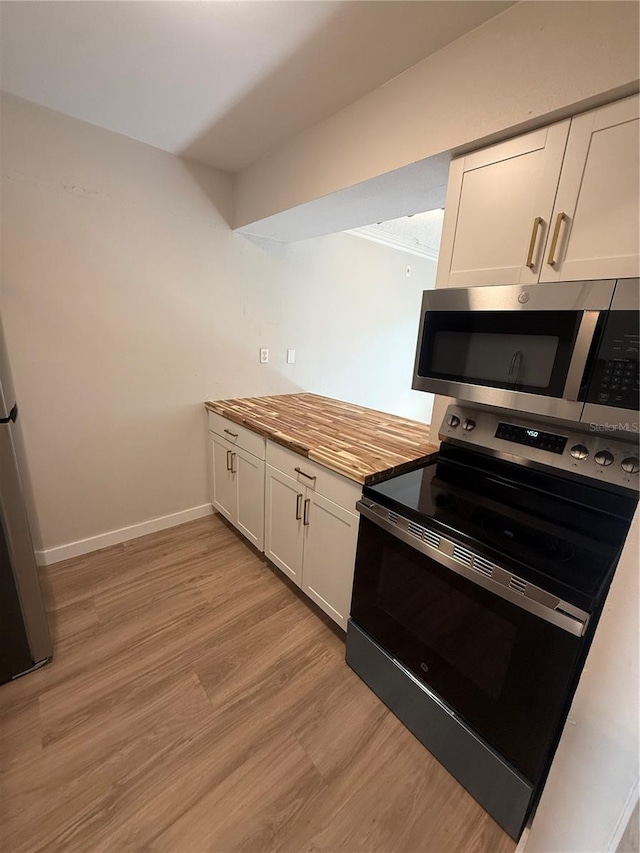 2613 Pine Lake Ter Unit C, Sarasota, FL 34237 - kitchen featuring appliances with stainless steel finishes, white cabinets, and light wood-style floors