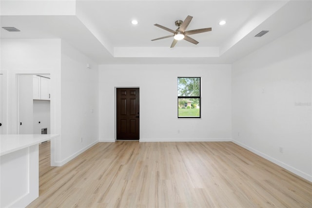 1532 Maricopa Rd, North Port, FL 34287 - unfurnished living room with a tray ceiling, light wood-style flooring, ceiling fan, and recessed lighting