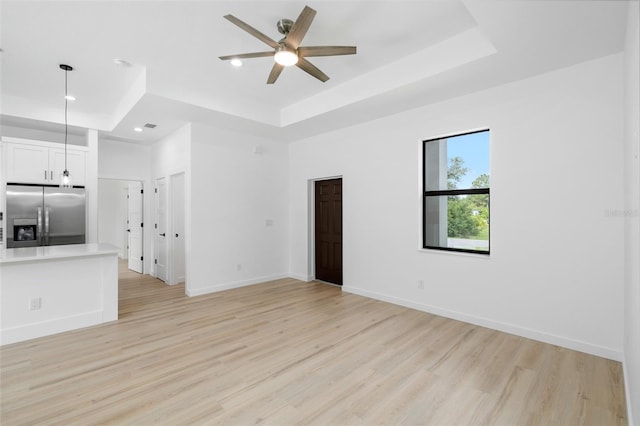 1532 Maricopa Rd, North Port, FL 34287 - unfurnished living room featuring a tray ceiling, a ceiling fan, light wood finished floors, and recessed lighting