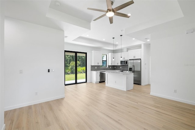 1532 Maricopa Rd, North Port, FL 34287 - kitchen featuring stainless steel appliances, a tray ceiling, open floor plan, backsplash, and ceiling fan