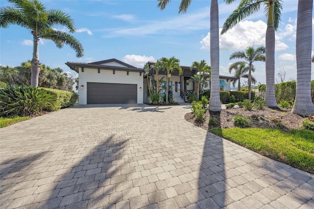 5569 Cape Leyte Dr, Sarasota, FL 34242 - view of front facade with decorative driveway, an attached garage, stucco siding, and covered porch