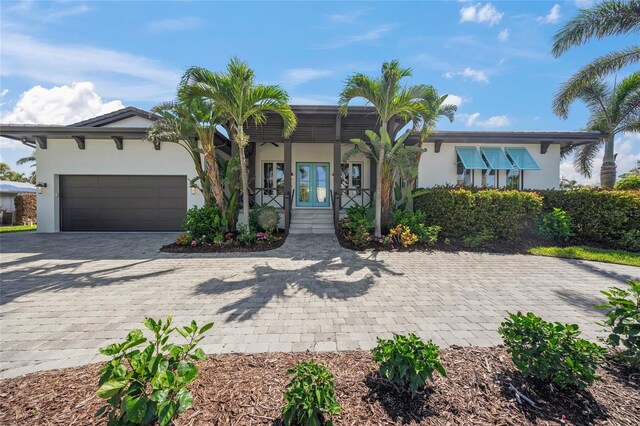 5569 Cape Leyte Dr, Sarasota, FL 34242 - view of front of home with french doors, stucco siding, decorative driveway, and a garage