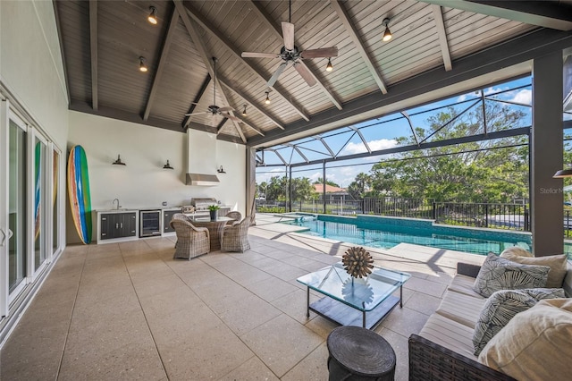 5569 Cape Leyte Dr, Sarasota, FL 34242 - view of patio with exterior kitchen, ceiling fan, outdoor lounge area, beverage cooler, and glass enclosure