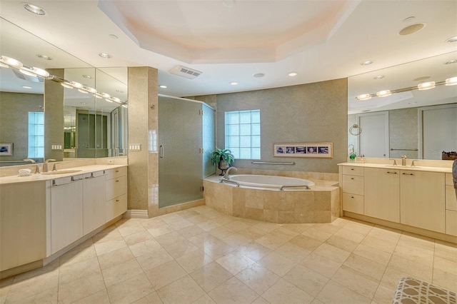 990 Blvd Of The Arts Unit 801, Sarasota, FL 34236 - full bathroom featuring a tray ceiling, a shower stall, a garden tub, two vanities, and tile patterned flooring