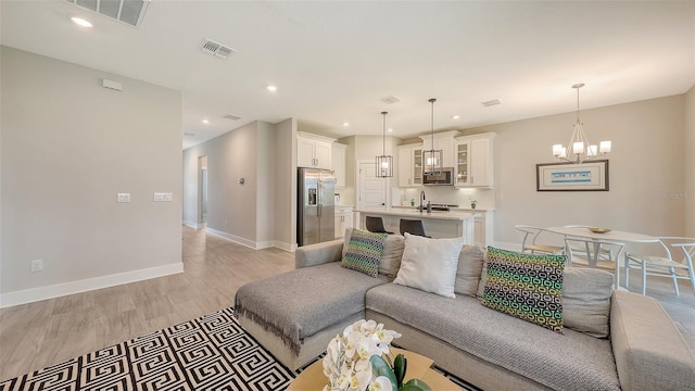 491 Daylily Blvd, Nokomis, FL 34275 - living room with a chandelier, recessed lighting, and light wood-style flooring