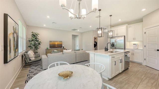 491 Daylily Blvd, Nokomis, FL 34275 - kitchen featuring appliances with stainless steel finishes, a kitchen island with sink, a chandelier, recessed lighting, and white cabinetry