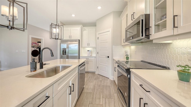 491 Daylily Blvd, Nokomis, FL 34275 - kitchen with stainless steel appliances, a chandelier, light countertops, white cabinets, and hanging light fixtures