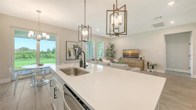 491 Daylily Blvd, Nokomis, FL 34275 - kitchen with a chandelier, dishwasher, open floor plan, light countertops, and white cabinetry