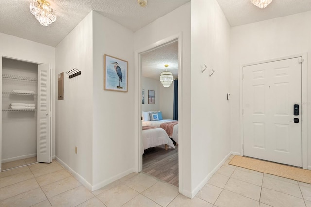 4411 46th Ave W Unit 201, Bradenton, FL 34210 - foyer entrance featuring light tile patterned floors, a textured ceiling, and a chandelier