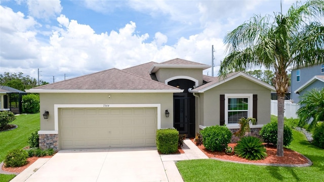 7364 47th Avenue Cir E, Bradenton, FL 34203 - view of front of home with stucco siding, an attached garage, a front lawn, and driveway