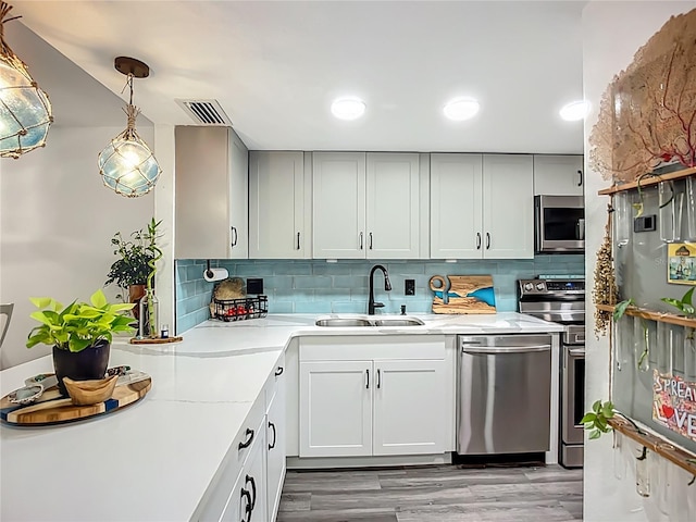 3700 S Osprey Ave Unit 122, Sarasota, FL 34239 - kitchen with stainless steel appliances, backsplash, and light wood-style floors