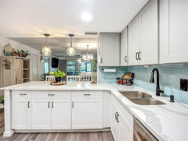 3700 S Osprey Ave Unit 122, Sarasota, FL 34239 - kitchen with a peninsula, tasteful backsplash, stainless steel dishwasher, and light wood-style floors