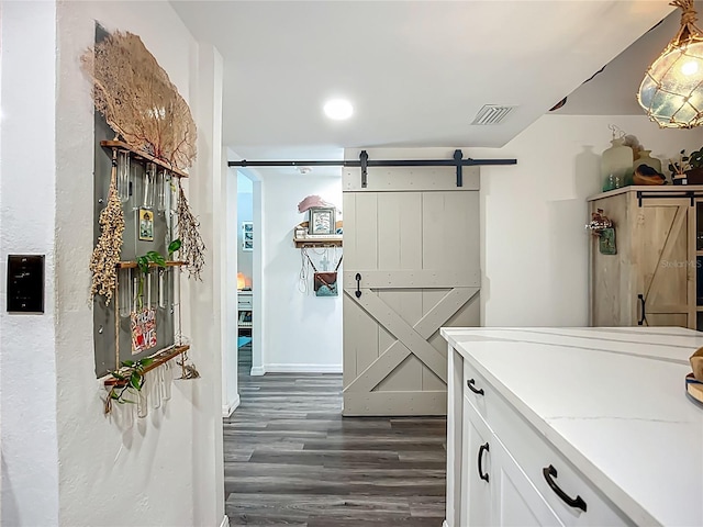 3700 S Osprey Ave Unit 122, Sarasota, FL 34239 - hall featuring a barn door and dark wood-type flooring