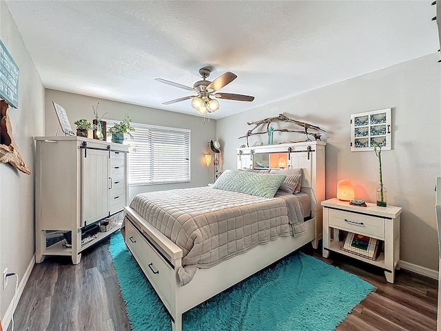 3700 S Osprey Ave Unit 122, Sarasota, FL 34239 - bedroom featuring dark wood-style flooring, ceiling fan, and a barn door
