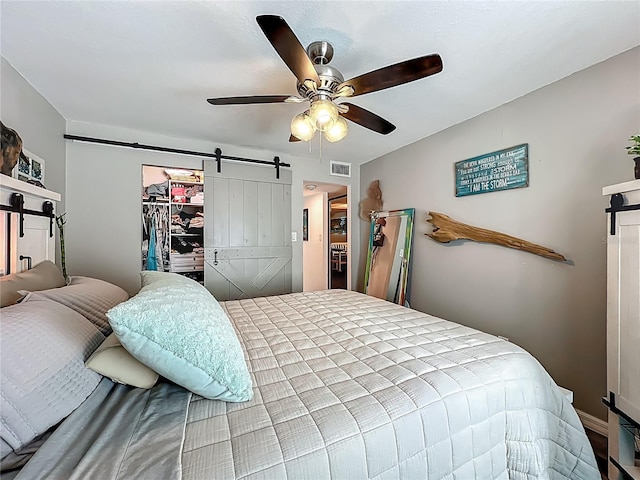 3700 S Osprey Ave Unit 122, Sarasota, FL 34239 - bedroom featuring a barn door, a ceiling fan, a walk in closet, and a closet