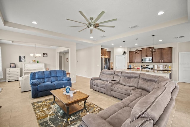 226 Tapa Parish Run, Bradenton, FL 34212 - living room with light tile patterned floors, ceiling fan, a chandelier, a tray ceiling, and recessed lighting