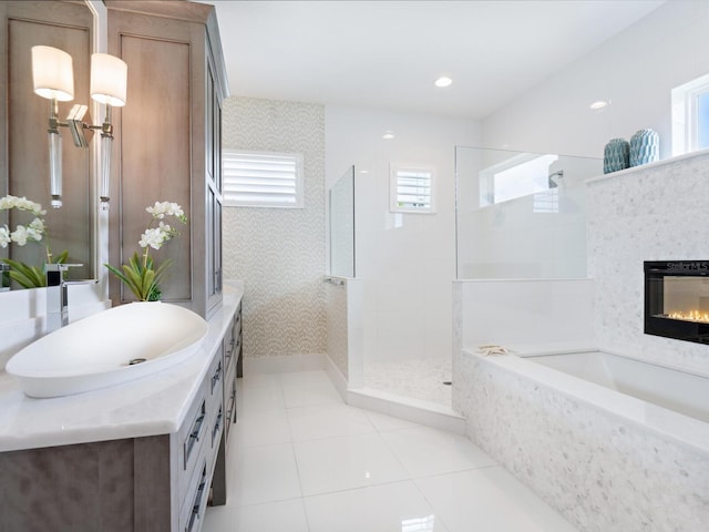 5630 Inspiration Ter, Bradenton, FL 34210 - bathroom with vanity, a garden tub, a walk in shower, tile patterned floors, and a glass covered fireplace