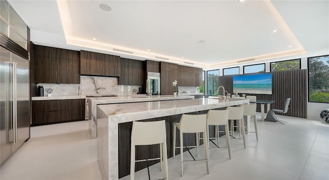 1610 N Lodge Dr, Sarasota, FL 34239 - kitchen with modern cabinets, a tray ceiling, a breakfast bar, a spacious island, and recessed lighting