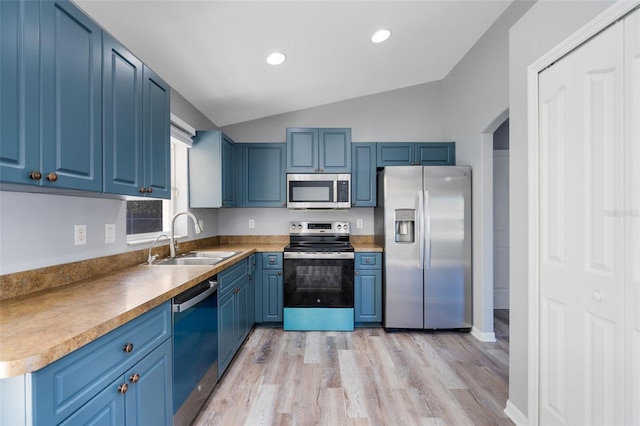 2405 Mistleto Ln, North Port, FL 34286 - kitchen with stainless steel appliances, blue cabinetry, vaulted ceiling, light wood finished floors, and recessed lighting