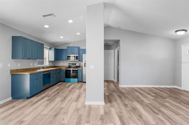 2405 Mistleto Ln, North Port, FL 34286 - kitchen featuring appliances with stainless steel finishes, blue cabinets, light wood-style flooring, vaulted ceiling, and recessed lighting