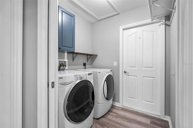 2405 Mistleto Ln, North Port, FL 34286 - laundry room featuring independent washer and dryer, wood finished floors, and cabinet space