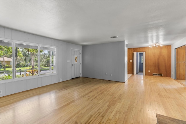 2850 Bon Air Ave, Sarasota, FL 34234 - unfurnished living room with light wood-type flooring and wooden walls