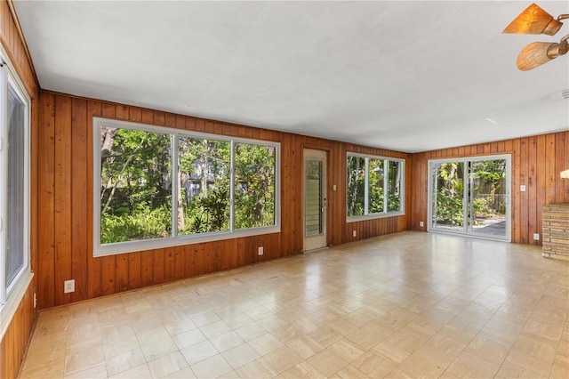 2850 Bon Air Ave, Sarasota, FL 34234 - unfurnished room with plenty of natural light, wooden walls, light floors, and a ceiling fan
