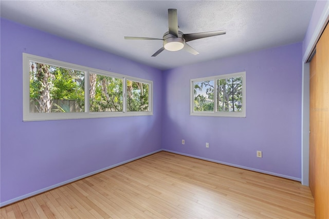 2850 Bon Air Ave, Sarasota, FL 34234 - unfurnished bedroom featuring light wood-type flooring, a ceiling fan, a textured ceiling, and a closet