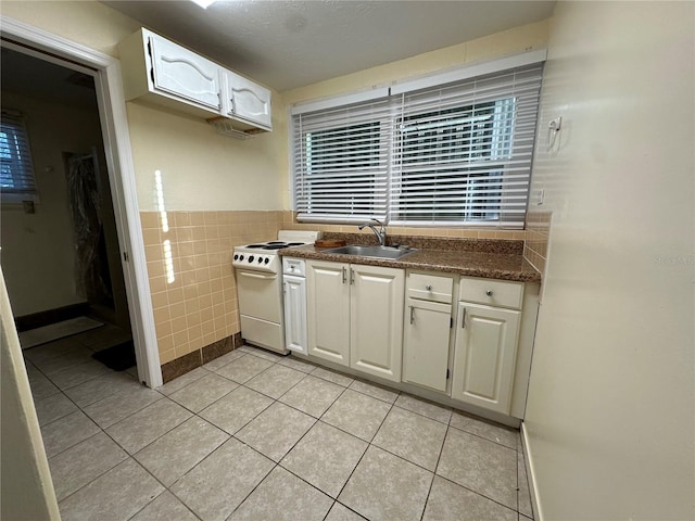 408 3rd Ave E Unit A, B & C, Bradenton, FL 34208 - kitchen with white electric stove, tile walls, light tile patterned flooring, white cabinetry, and dark countertops