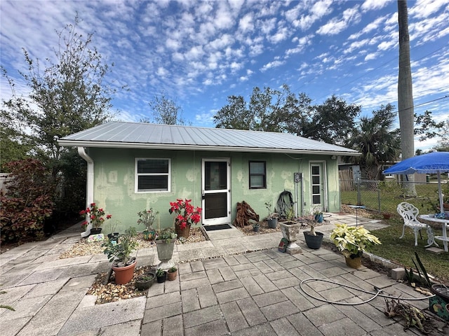 408 3rd Ave E Unit A, B & C, Bradenton, FL 34208 - back of property featuring stucco siding, a patio, and a metal roof