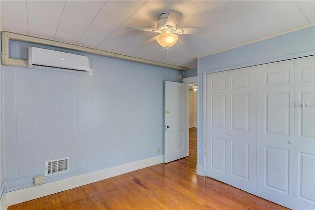 408 3rd Ave E Unit A, B & C, Bradenton, FL 34208 - unfurnished bedroom with a wall unit AC, wood finished floors, a closet, and a ceiling fan