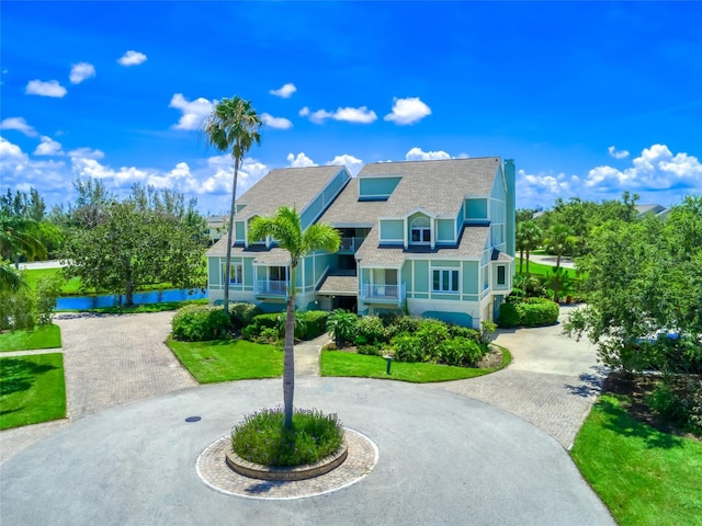 123 Tidy Island Blvd, Bradenton, FL 34210 - view of front of house featuring curved driveway, a shingled roof, and stucco siding