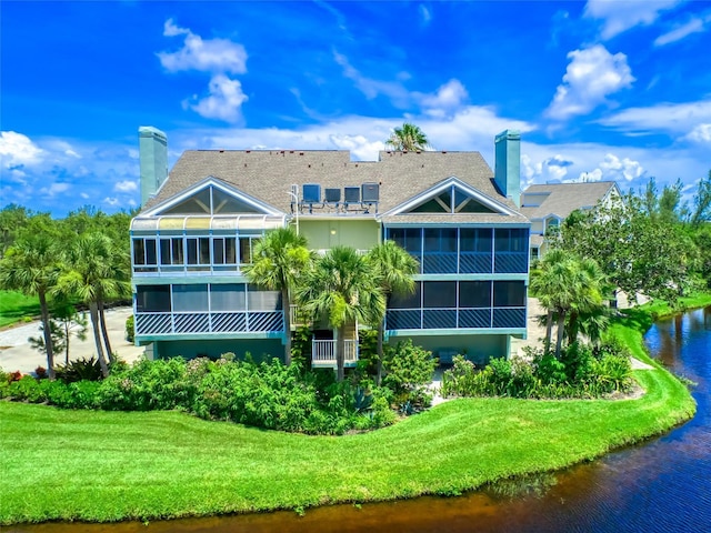 123 Tidy Island Blvd, Bradenton, FL 34210 - rear view of property featuring a chimney, a sunroom, a yard, and a water view