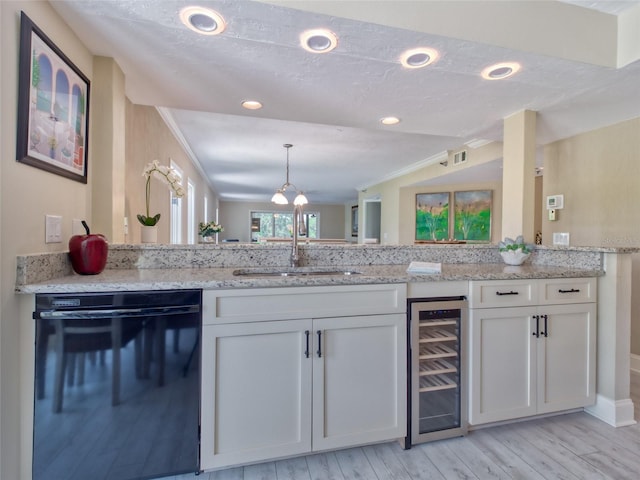 123 Tidy Island Blvd, Bradenton, FL 34210 - kitchen with dishwasher, beverage cooler, white cabinetry, light wood-style flooring, and light stone counters