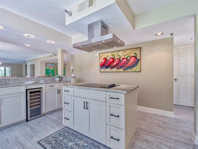 123 Tidy Island Blvd, Bradenton, FL 34210 - kitchen featuring beverage cooler, range hood, black electric cooktop, light wood-type flooring, and white cabinetry