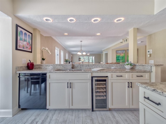123 Tidy Island Blvd, Bradenton, FL 34210 - kitchen with wine cooler, dishwasher, white cabinets, light stone counters, and light wood-type flooring