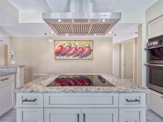 123 Tidy Island Blvd, Bradenton, FL 34210 - kitchen with wall chimney exhaust hood, black electric cooktop, light stone counters, stainless steel double oven, and recessed lighting